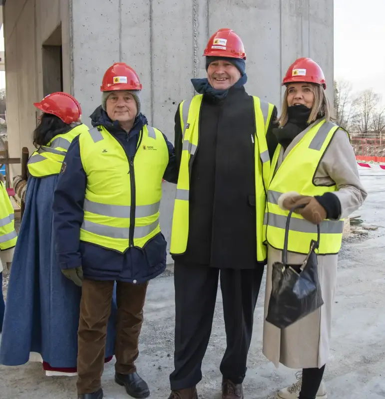 Knut Storberget, Sven Inge Sunde og Inga Borud står på byggeplassen til Regionalt Historiesenter iført refleksvester og hjelm.