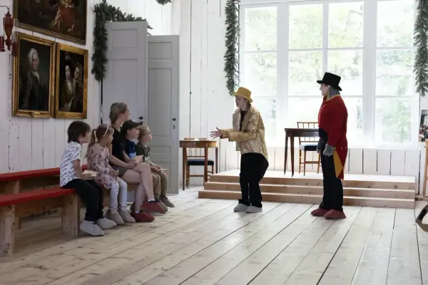 Vandreteater for barn i Eidsvollsbygningen, med skuespillere i historiske kostymer.