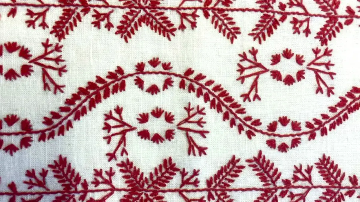 Rött broderi på vitt tyg